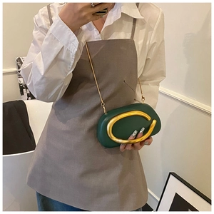 Close-up of dark green pebble leather bag with large gold metal ring and chain detail