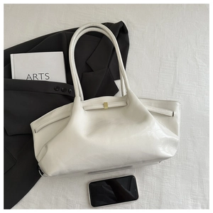 Detalle del bolso tote crema con hebilla metálica dorada y textura de cuero arrugado fino