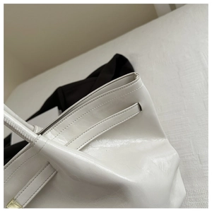 Detalle de primer plano de la textura de cuero brillante y hebilla en bolso blanco