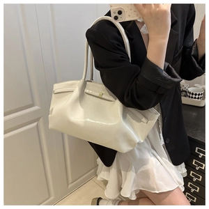 Detalle del bolso tote de charol blanco brillante con cierre de hebilla y asas elegantes