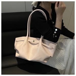 Detalle del bolso tote rosa claro brillante con textura de charol y correa delgada