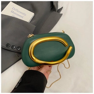 Detail of dark green acrylic oval clutch with luxury gold round metal handle and chain