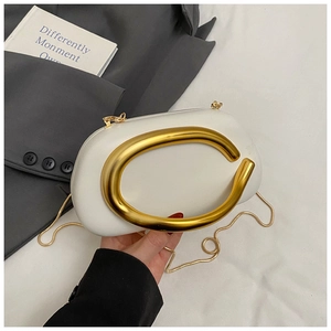 Detail of white cloud-shaped evening clutch bag with large gold metal round handle