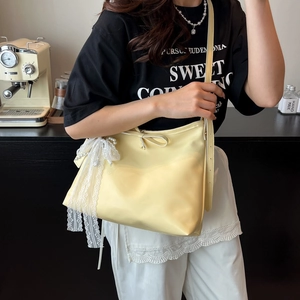 Chic cream leather tote bag with lace bow and pearl detail shown in a lifestyle setting