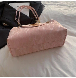 Detail der rosa Tragetasche mit Marmortextur, goldenem Kettenhemd und Metallschnalle