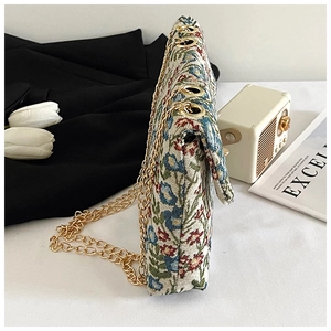 Detailed side view of floral tapestry crossbody bag with gold chain strap and texture
