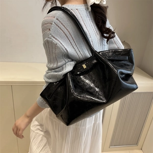 Bolso tote de charol brillante negro a la moda con elegantes hebillas doradas metálicas