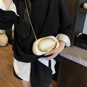 Minimalist beige leather shoulder bag with large gold C-clasp and chain strap