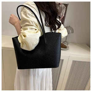 Detail of black woven texture and dual shoulder straps on a large capacity tote bag