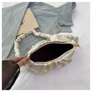 Détail du sac plissé à fleurs avec fermeture éclair et intérieur spacieux en tissu rouge