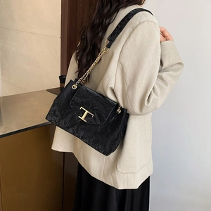 Moderne schwarze Schultertasche mit Plissee-Struktur, Goldkette und edlem T-Metallverschluss