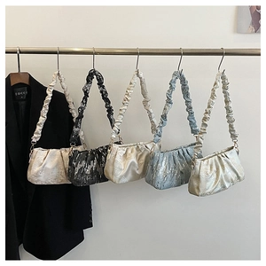 Vue détaillée de la texture en satin plissé et des divers coloris de sacs à main nuage