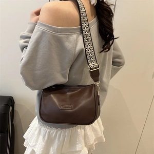 Classic dark brown Boston bag with a wide geometric strap shown in a fashion-forward pose