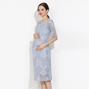 Détail d'une robe de maternité en dentelle bleu clair avec broderie florale et demi-manches