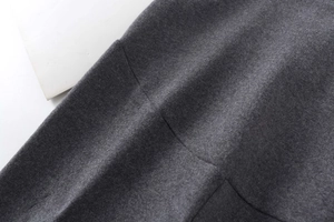 Détail macro du tissu en mélange de laine gris foncé avec couture et texture premium