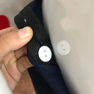 Detail of adjustable waist elastic band with button on maternity trousers for size flexibility