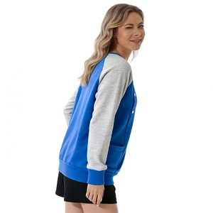 Detail of blue and grey patchwork sweatshirt featuring raglan sleeves and side pocket