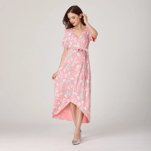 Détail de robe cache-cœur rose à imprimé fleuri avec ourlet asymétrique et lien
