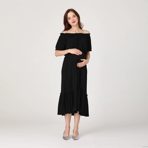 Detail of off-shoulder maternity dress with ruffled hem and elastic neckline in black