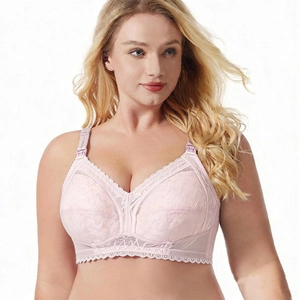 Close-up of light pink nursing bra featuring delicate lace patterns and wide straps