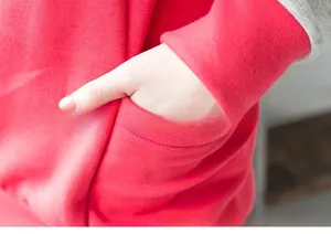 Detail view of the side pocket on a two-tone red and grey oversized nursing hoodie
