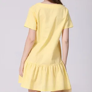 Back view of a light yellow short-sleeve maternity dress featuring a ruffled hem detail
