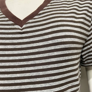 Détail du col en V et tissu en maille rayée marron sur un t-shirt de maternité à manches