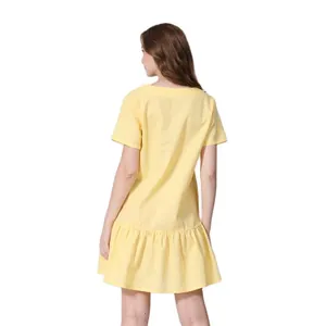 Detail of a yellow short-sleeved maternity dress with breathable fabric and ruffled hemline