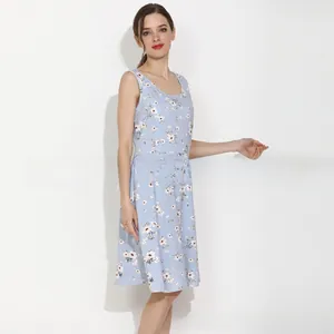 Gros plan d'une robe de maternité bleu clair avec motifs floraux blancs et sans manches