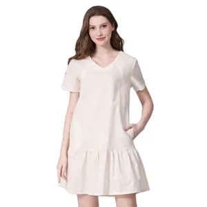Detail view of cream white maternity dress featuring V-neckline and ruffled hemline