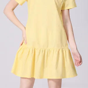 Close-up of light yellow maternity dress featuring soft cotton and ruffled hemline details