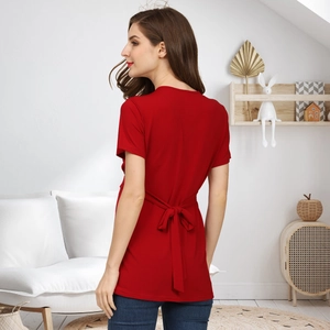 Detail of red maternity shirt featuring a stylish bow tie-back design and soft knit fabric