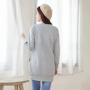 Détails du dos d'un sweat à capuche d'allaitement gris clair ample avec poches latérales