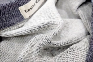 Detailed macro view of gray cotton nursing sweatshirt with French Terry texture and ribbed cuff