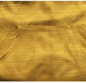 Détail d'un sweat de maternité jaune avec poche kangourou et texture tricotée
