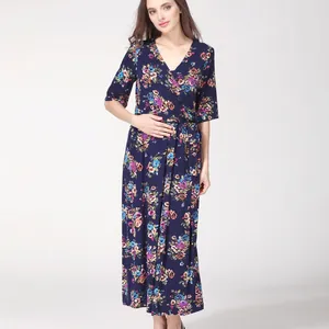 Macro detail of the V-neck wrap design and vibrant floral print on navy maternity dress