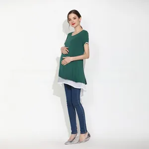 Detail of green maternity T-shirt with white ruffled hem and mock two-piece layered design