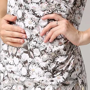 Detail of light grey summer nursing dress featuring white daisy print and soft cotton fabric