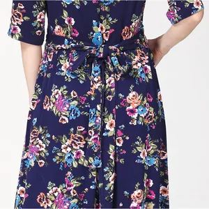 Detailed view of the adjustable floral print waist tie on a navy blue maternity dress
