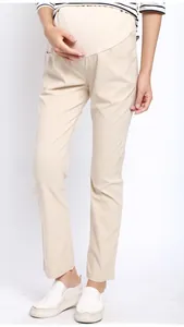 Detail view of the high waist maternity support band on beige straight-leg trousers