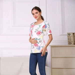 Detailed view of the vibrant floral print on a white cotton nursing shirt for maternity wear