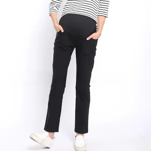 Detail of high-waisted black maternity pants with elastic belly support and side pockets