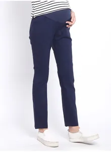 Detail of high-waist maternity trousers in dark blue with stretch belly support fabric