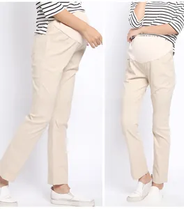 Detailed view of beige high-waist maternity pants showing elastic belly support and fit