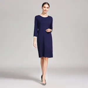 Detail of navy modal maternity dress featuring white lace cuffs on three-quarter sleeves