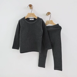 Detail showing the soft knitted texture of dark grey kids cotton loungewear set on a hanger