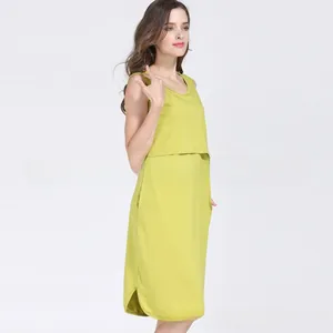 Detail view of grass green maternity dress featuring side pockets and layered cotton design