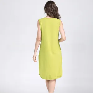 Back view of a simple sleeveless green cotton maternity dress with a straight-cut silhouette