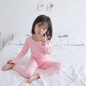 Close-up of pink cotton thermal pajama set for girls on a cozy bed setting