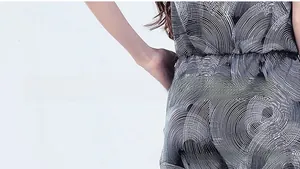 Detail of V-neck maternity jumpsuit featuring black and white concentric circle print